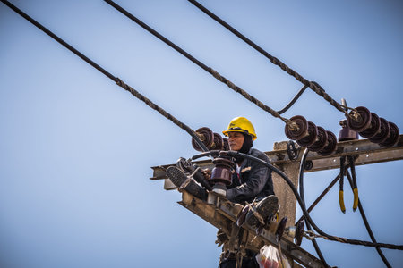 Electrician working on the electricity pole