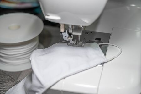 People sew the white face mask to protect themselves from the situation of Covid 19の写真素材