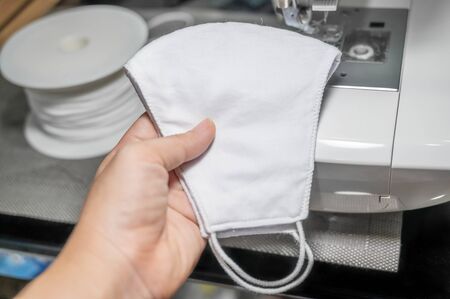 People sew the white face mask to protect themselves from the situation of Covid 19の写真素材