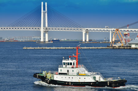 Scenery of a bridge and the tugboat of a blue sky and the port which it was fine in Japanese...