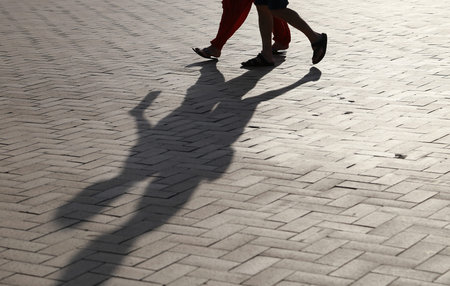Shadow of the person by the setting sun of the evening