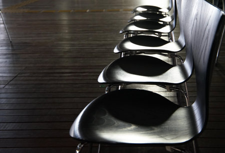 Many monochrome chairs lined up in a straight line