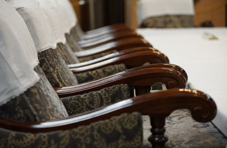 Table and many wooden chairs in the room