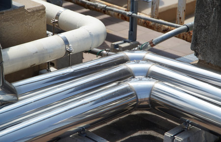 Silver metal air conditioning piping pipes on the roof of the buildingの写真素材