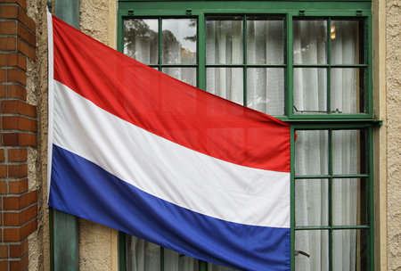 The tricolor Dutch flag in front of the window