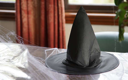 Witch`s black pointy hat on the tableの写真素材