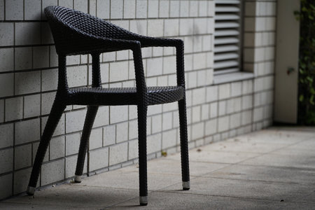 Chairs placed in the aisle by the wall of the buildingの写真素材