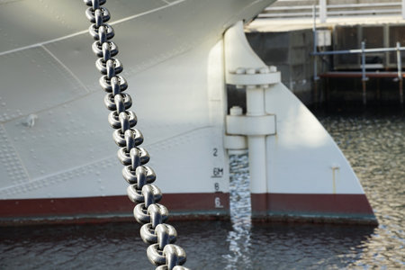 Rudder at the stern of a ship moored in harbor by chainsの写真素材