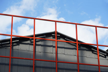 Building walls, triangular roof and red steel frameの写真素材