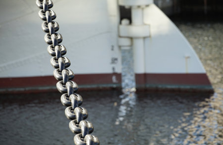 Chain and stern of a ship anchored in the harbor on a clear dayの写真素材