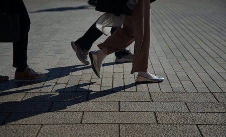 Legs of a young man and a woman walking on the street