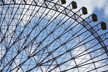 ferris wheel against the blue sky and clouds, closeup of photoの写真素材