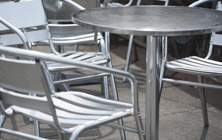 Empty tables and chairs in a street cafe, closeup of photoの写真素材