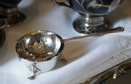 Vintage metal tea strainer on the table. Selective focus.