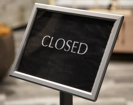 Closed sign on a shop window at the entrance to the storeの写真素材