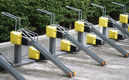 Bicycle parking lot with yellow and black handrails in parkの写真素材