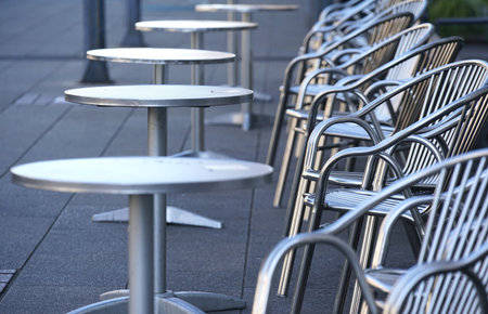 Tables and chairs in a street cafe, closeup of photo