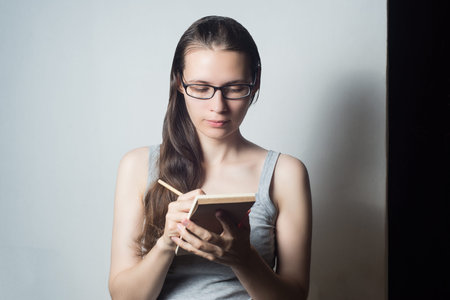 Young woman writing on a note book
