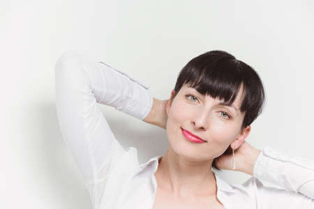 Beautiful young model woman in white shirt posing over white  backgroundの写真素材