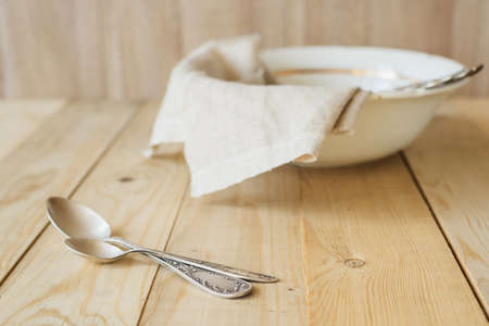two tablespoons on a background of a linen cloth in the bowl, wooden interiorの写真素材