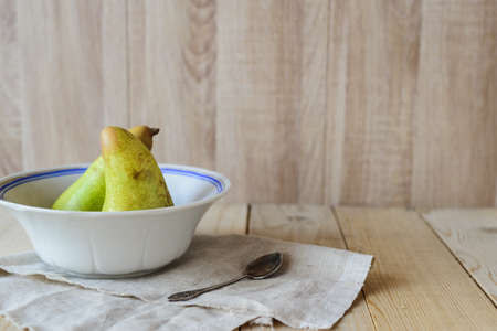 wooden background with copyspace, two pears in a bowlの写真素材