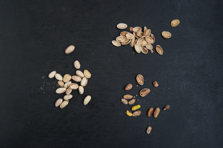 pile of pistachios on a black slate surface