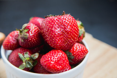 Freshly harvested strawberries in a white dish