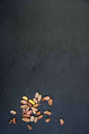 pile of pistachios on a black slate surfaceの写真素材