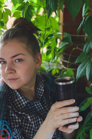 caucasian young woman drinking some hot beverage