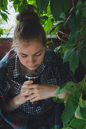 caucasian young woman drinking some hot beverageの写真素材