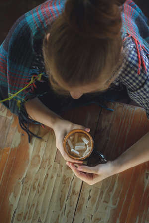 caucasian young woman drinking cocoa with marshmallowの写真素材