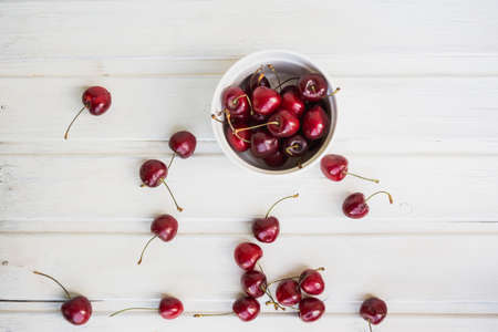 cherries in bowl and near on white backgroundの写真素材