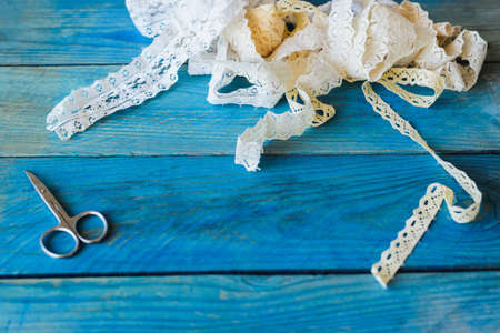 lace ribbon and scissors on wooden backgroundの写真素材