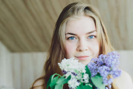 girl with white and purple lilac in the handsの写真素材