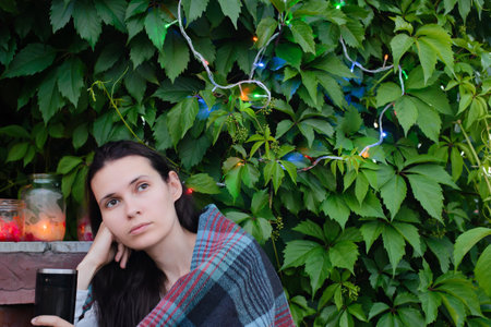 adult girl with cup on background of leaves
