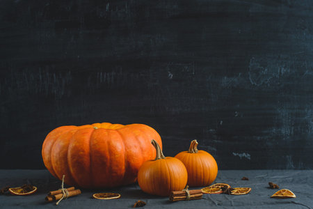 Festive still life of pumpkins, orange slices, cinnamon and star anise