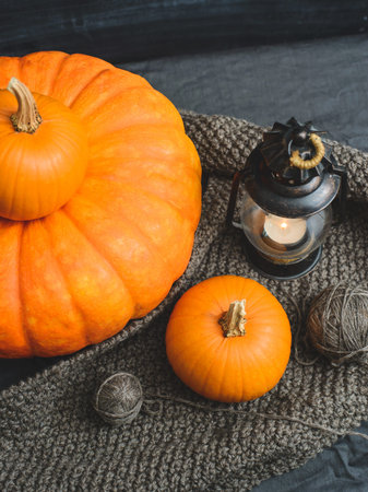 composition of three pumpkins, candles and knitting
