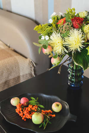 bouquet of apple, Chrysanthemum, rowan, stonecrop, anisetree, phlox near edible ingredients on plateの写真素材