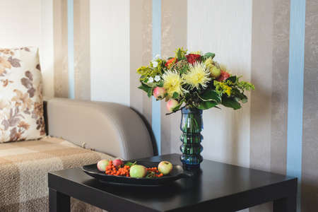 bouquet of apple, Chrysanthemum, rowan, stonecrop, anisetree, phlox near edible ingredients on plateの写真素材