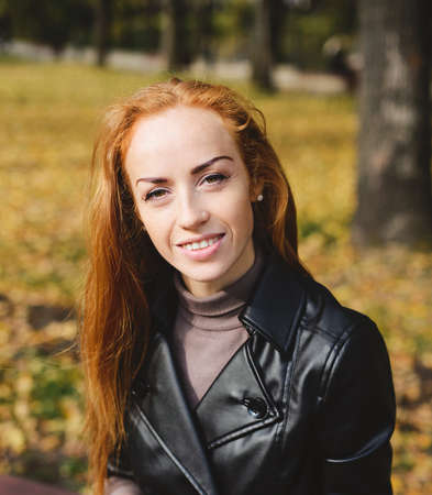 haired young woman posing in the autumn parkの写真素材