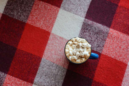 top view cup of cocoa with marshmallows on red checkered backgroundの写真素材