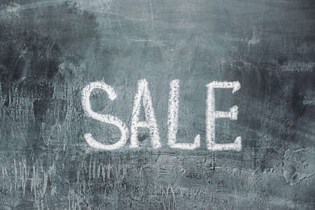 hand drawn lettering of sale in chalk on black slate with copy space for your textの写真素材