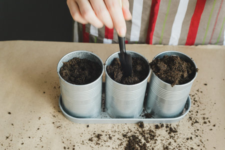 Woman planting seeds in metal pots