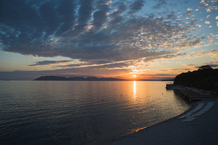 sunset over empty black sea beach and sky on twilight, horizontal stock photo image