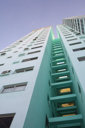 Modern tall apartment building, with moon in the blue skyの写真素材