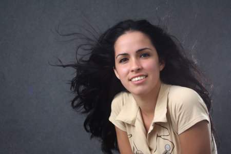 Beautiful caucasian girl smiling with blowing up hairの写真素材