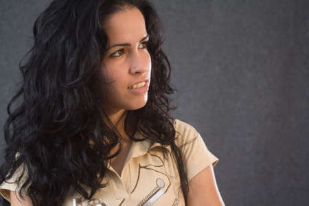 Beautiful black haired girl smiling and looking to a sideの写真素材