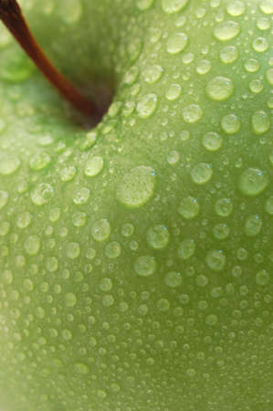 Green, fresh apple with drops of waterの写真素材