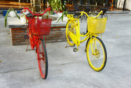 two red and yellow bicycles inside of a cafe on a terraceの写真素材