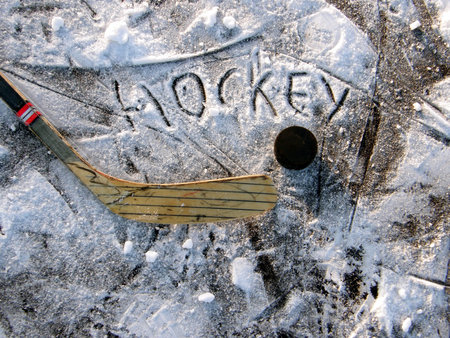 hockey stick and puck on the ice of a lake       